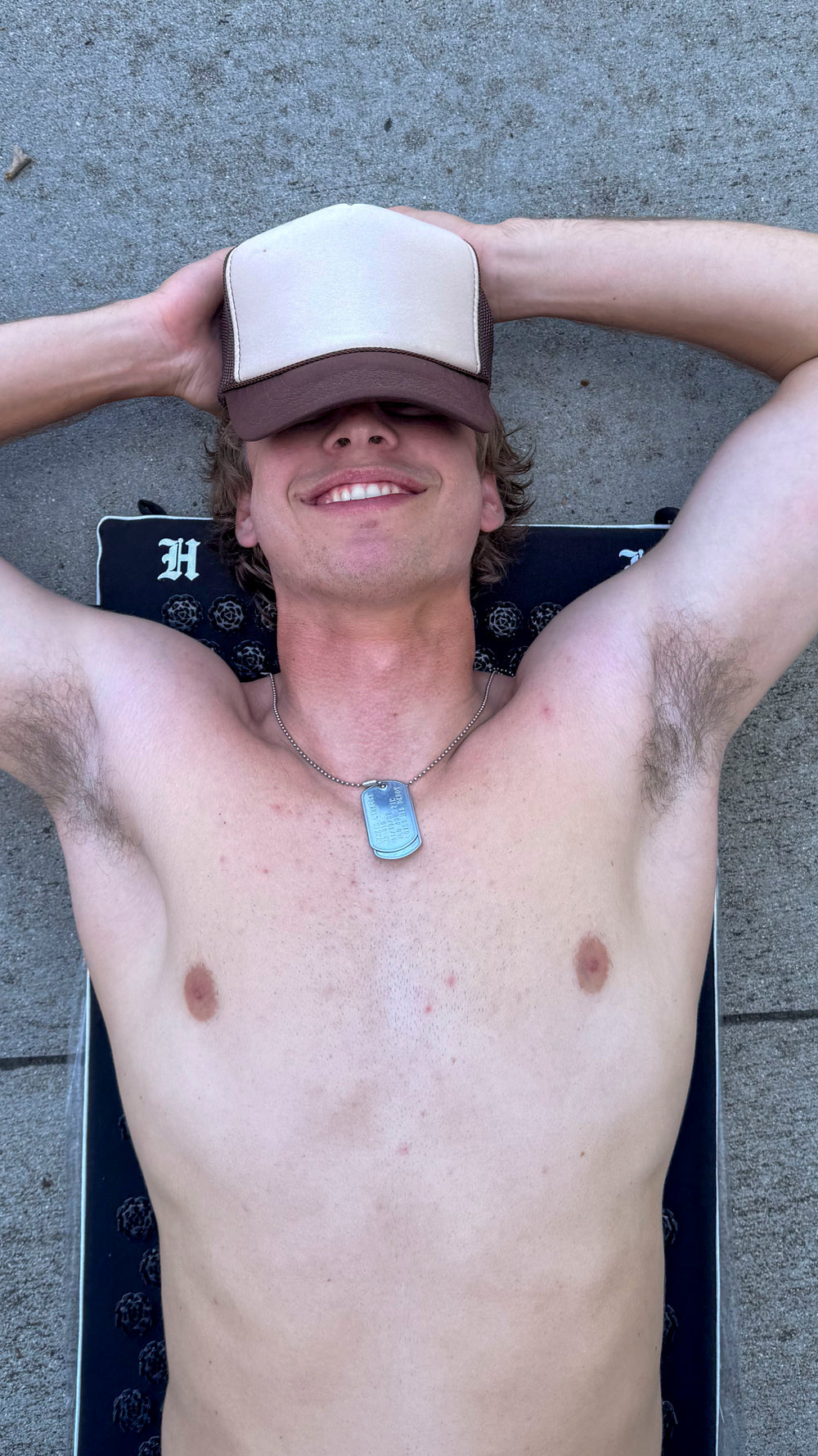 man laying on acupressure mat with hands on head